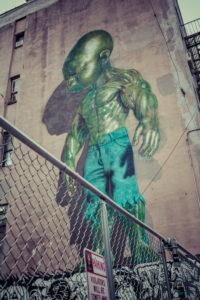Backyard scene Graffiti of a green superpower baby, Little Italy, Manhattan, New York, USA Backyard scene Graffiti of a green superpower baby, Little Italy, Manhattan, New York, USA
